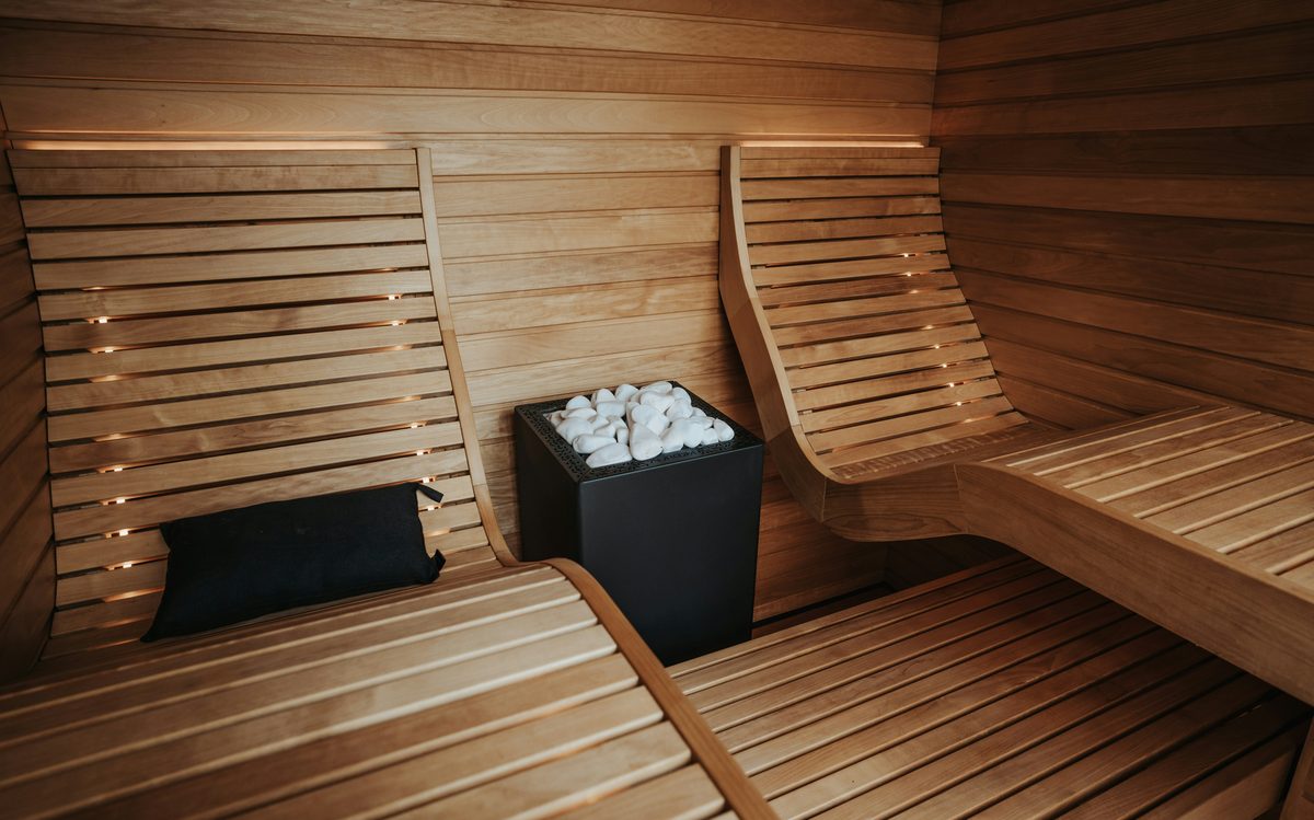 Wooden sauna interior with heated benches and stones